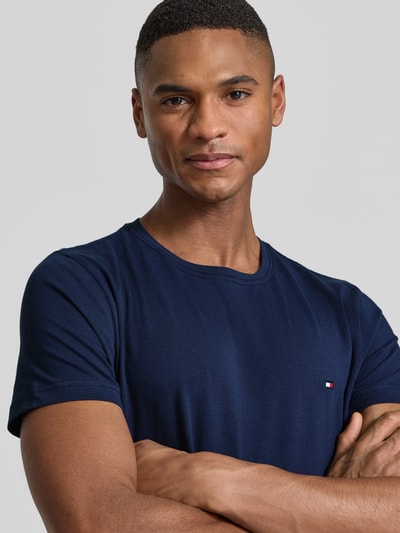Männermodel trägt Slim Fit T-Shirt aus Baumwoll-Mix von Tommy Hilfiger, Optik: unifarben, Logo-Detail, Rundhals, Kurzarm, Nahaufnahme Oberkörper