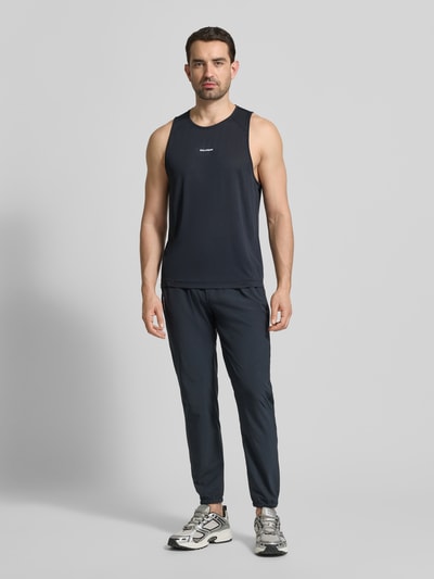 Männermodel trägt schwarzes Tanktop mit Rundhalsausschnitt Modell 'SHKOUT CORE' von Salomon, Mesh, körpernahe Passform, Ganzkörperansicht von vorne.