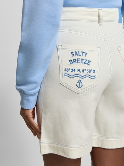 Frauenmodel trägt Jeansshorts mit Eingrifftaschen von Marc Cain aus Baumwoll-Elasthan-Mix in Off-White, Regular-Fit, Detailaufnahme Rückansicht.