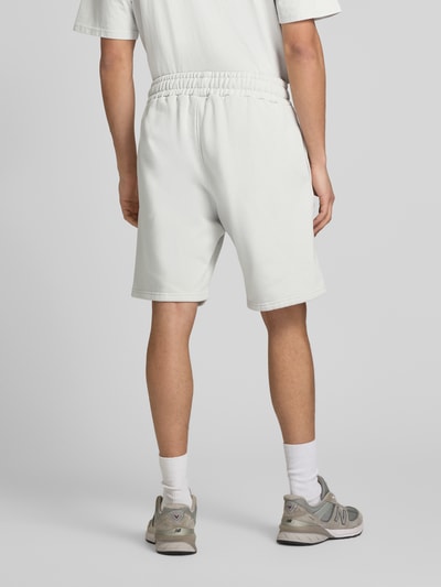 Männermodel trägt Shorts mit elastischem Bund und Logo-Stitching von Pegador, Baumwoll-Mix, Loose-Fit, Ganzkörperansicht Rückansicht.