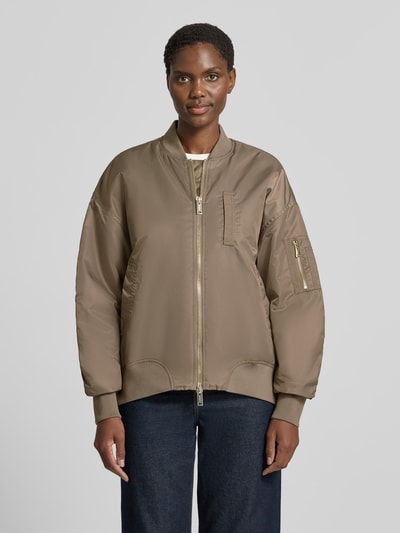Vrouwenmodel draagt Relaxed Fit Bomberjacke met Stehkragen Model 'Ruby' van MOS MOSH in beige met steekzakken, tweewegritssluiting, elastische boordjes, ruglengte maat S 56 cm, schouderbreedte 58 cm, borstwijdte 61 cm, mouwlengte 57 cm, Ganzkörperansicht van voren.