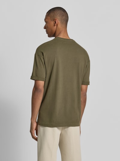 Männermodel trägt T-Shirt mit Ärmelaufschlag und Rundhalsausschnitt von Drykorn in Oliv, Reine Baumwolle, Regular-Fit, Rückenlänge 70 cm, Ganzkörperansicht Rückansicht.