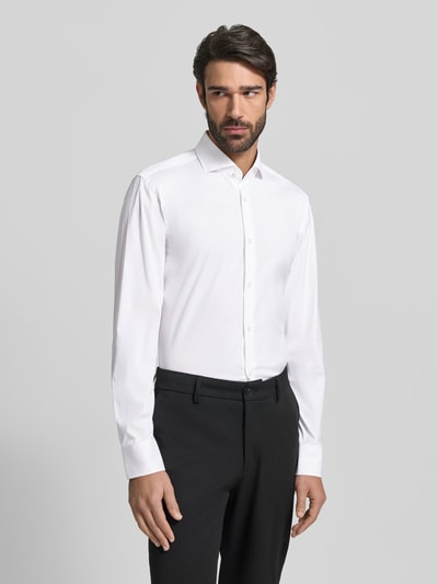 Männermodel trägt Slim Fit Business-Hemd mit Stretch-Anteil Modell 'Hank Hai' von BOSS, Weiß, Unifarbenes-Design, Ganzkörperansicht von vorne. Baumwoll-Mix, Haifischkragen, durchgehende Knopfleiste, Sportmanschetten, abgerundeter Saum, schlichte Textur. Rückenlänge 78 cm, Schulterbreite 48 cm, Ärmellänge 68 cm bei Größe 40.