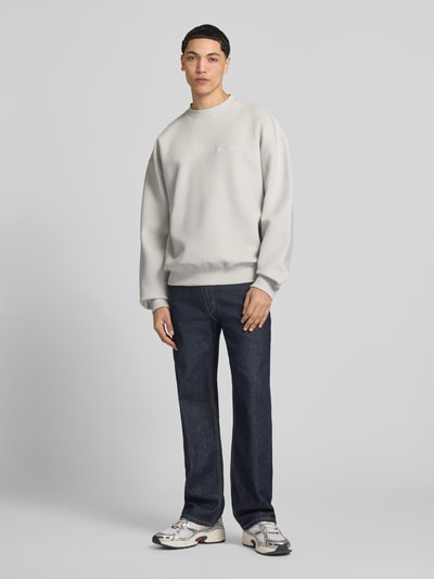 Männermodel trägt Oversized Fit Sweatshirt mit Logo-Stitching Modell 'Tate' van Pegador in lichtgrijs, gestructureerde stof, elastische boorden, ronde hals, heren sweat van katoenmix, vooraanzicht volledige lichaam.