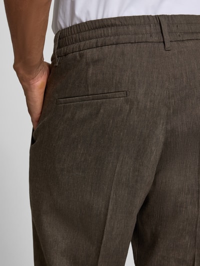 Männermodel trägt Hose mit Bügelfalte und elastischem Bund Modell 'CHASY' von Drykorn, Leinen-Mix mit Viskose-Anteil, Slim-Fit, Detailaufnahme Rückansicht, sichtbare Gesäßtasche und Bund.