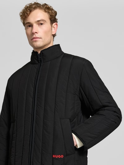 Männermodel trägt schwarze Regular Fit Steppjacke Modell 'Brenoto2611' von HUGO, glatte Struktur, Nahaufnahme Oberkörper, Herren Steppjacke von HUGO.