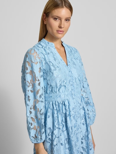 Frauenmodel trägt Knielanges Cocktailkleid aus Spitze mit Knopfleiste von V by Vera Mont in Hellblau, A-Linie, Material-Mix mit Baumwoll-Anteil, V-Ausschnitt, feine transparente Textur, Nahaufnahme Oberkörper.