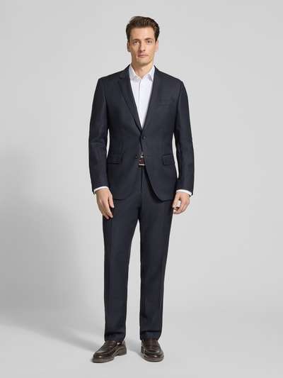 Männermodel trägt Regular Fit Business Hemd mit Kentkragen von Christian Berg Men in Weiß, kombiniert mit dunklem Anzug, Ganzkörperansicht von vorne. Elastischer Baumwoll-Mix, lange Ärmel, abgerundeter Saum, dezente Knopfleiste.