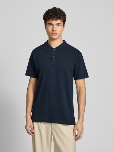 Männermodel trägt Regular Fit Poloshirt mit Logo von G-Star Raw aus Reine Baumwolle, Knopfleiste, Rückenlänge 74 cm, Ganzkörperansicht von vorne.