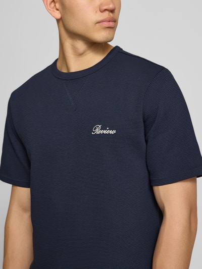 Männermodel trägt T-Shirt mit Label-Stitching von REVIEW aus Baumwoll-Mix, navy, Waffelstruktur, gerader Schnitt, Nahaufnahme Oberkörper.