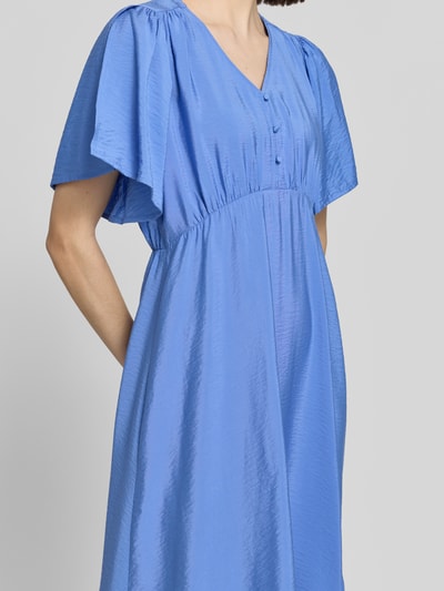 Frauenmodel trägt Midikleid aus Viskose-Mix mit V-Ausschnitt Modell 'Aniva' von ICHI in Blau, strukturierte Oberfläche, Nahaufnahme Oberkörper, Tailliert, Passform, Kurzärmelig, Knopfleiste, Rückenlänge bei Größe 36: 116 cm, Brustweite bei Größe 36: 34 cm, Ärmellänge bei Größe 36: 26 cm.