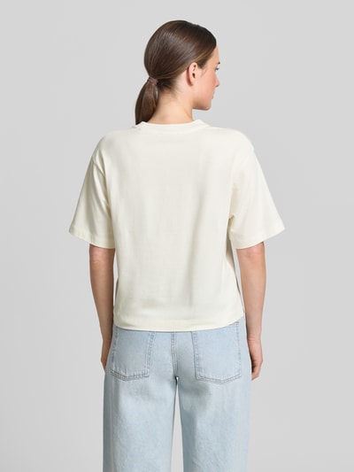 Frauenmodel trägt Regular-Fit T-Shirt aus Baumwoll-Mix von Marc O'Polo, Damen T-Shirt in Creme, glatte Textur, hellblaue Jeans, Ganzkörperansicht Rückansicht.
