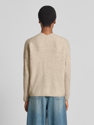 Vrouwenmodel draagt gebreide pullover uit wolmix met alpaca, regular fit, v-hals, Model 'THORA' van MOS MOSH, ruglengte maat S 82 cm, mouwlengte maat S 46 cm, lichte beige tint, subtiele ribstructuur, model van achteren volledig zichtbaar, Ganzkörperansicht Rückansicht.