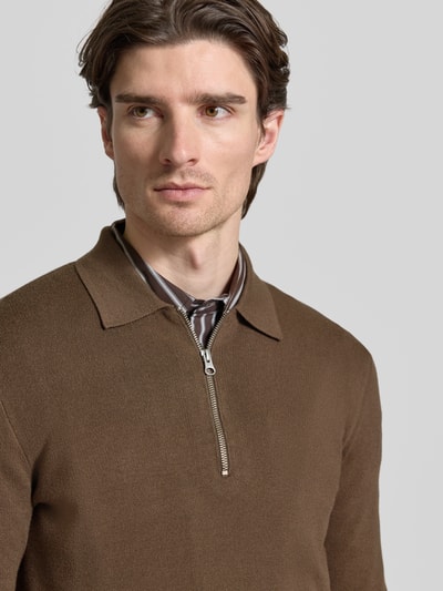 Męski model nosi brązowy Slim Fit Pullover mit Polokragen Modell 'GUNA' od Samsøe Samsøe z zamkiem, zbliżenie na górną część ciała.