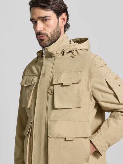 Männermodel trägt Oversized Funktionsjacke mit abnehmbarer Kapuze Modell 'BALTERO2611' von HUGO, unifarben, wasserabweisend, Nahaufnahme Oberkörper.