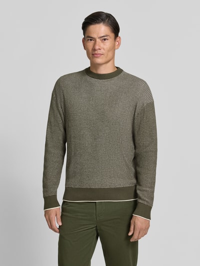 Männermodel trägt Regular Fit Strickpullover aus reiner Baumwolle von HECHTER PARIS in Olivgrün mit Rundhalsausschnitt, Nahaufnahme Oberkörper.