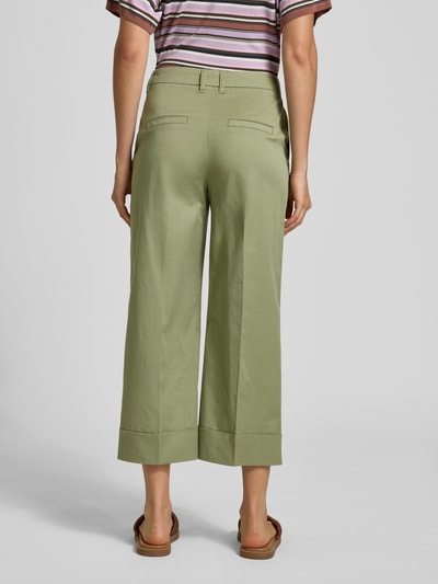 Frauenmodel trägt Wide Leg Culotte aus Baumwoll-Mix von s.Oliver RED LABEL in Hellgrün mit Bügelfalten, Rückansicht, Ganzkörperansicht.