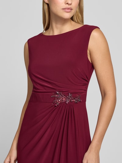 Frauenmodel trägt Abendkleid mit Raffungen von Adrianna Papell in dunklem Rot, Material-Mix, Pailletten, tailliert, Nahaufnahme Oberkörper.