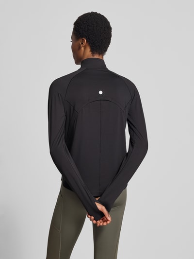 Frauenmodel trägt Longsleeve mit Troyer-Kragen Modell 'NAGINO' von ASICS TIGER in Schwarz, Regular Fit, Rückansicht Ganzkörperansicht.