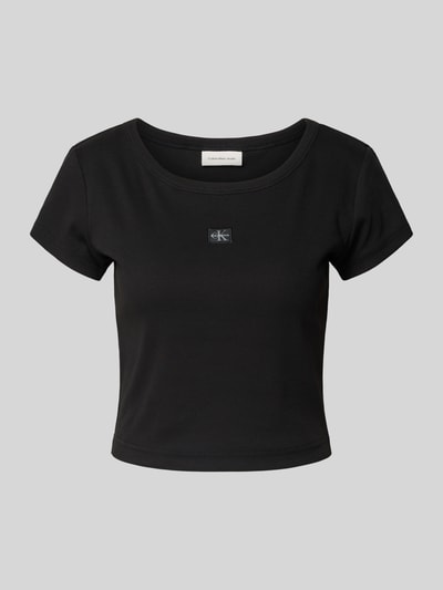 Produktfoto, Cropped T-Shirt mit Label-Detail von Calvin Klein Jeans, damski t-shirt, mieszanka bawełny i elastanu, okrągły dekolt, czarny, krój krótki, detal z logo, długość tyłu 43 cm w rozmiarze S.
