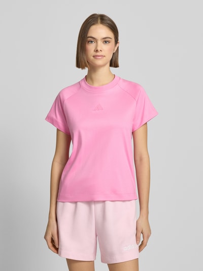 Frauenmodel trägt T-Shirt mit Logo und Rundhalsausschnitt von adidas Sportswear in Pink, reine Baumwolle, Regular-Fit, Ganzkörperansicht von vorne.