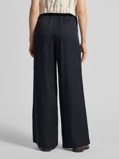 Frauenmodel trägt Wide Leg Stoffhose mit elastischem Bund von Lanius aus Lyocell, Eingrifftaschen, dunkel, Ganzkörperansicht Rückansicht.