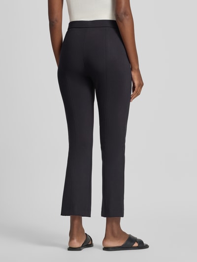 Frauenmodel trägt Regular Fit Schlaghose in 7/8 Länge Modell 'MACY' von Raffaello Rossi in Schwarz, glatte Textur, Ganzkörperansicht Rückansicht. Damen Schlaghose von Raffaello Rossi.