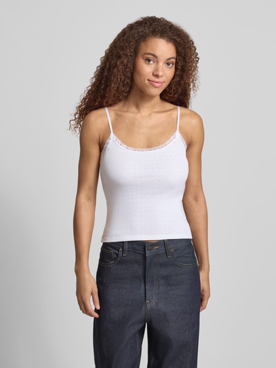 Frauenmodel trägt Slim Fit Top mit Spitzenbesatz von REVIEW in Weiß, reine Baumwolle, Spaghettiträger, Zierschleifen, Ganzkörperansicht von vorne.