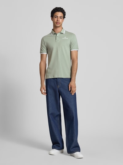 Männermodel trägt Slim Fit Poloshirt mit Logo-Stitching Modell 'Reed' von SERGIO TACCHINI in hellem Grün, Kurzarm, elastischer Baumwoll-Mix, Ganzkörperansicht von vorne.