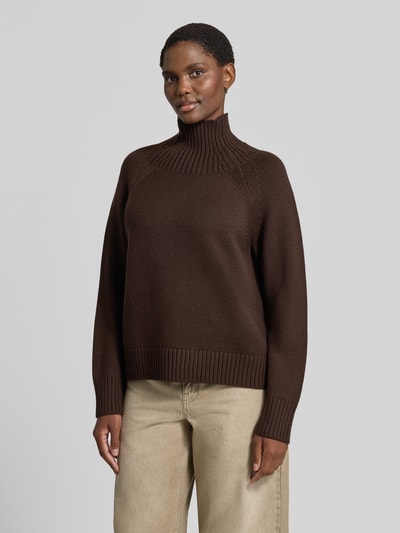 Frauenmodel trägt Strickpullover aus reinem Leinen von MICHAEL Michael Kors in Braun, lockere Passform, Stehkragen, Ganzkörperansicht von vorne.
