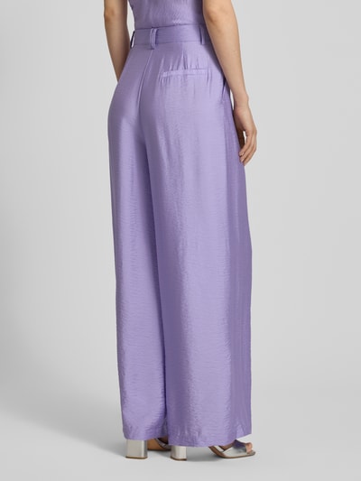 Frauenmodel trägt Wide Fit Stoffhose aus Viskose-Mix Modell 'Finja' von GUIDO MARIA KRETSCHMER WOMAN in Flieder mit Bundfalten, Haken- und Reißverschluss, glatte Textur, Ganzkörperansicht Rückansicht.
