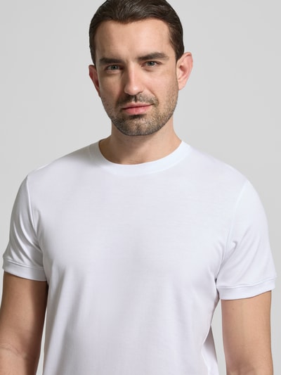 Męskimodel nosi T-Shirt mit Rundhalsausschnitt od RAGMAN, krój slim fit, bawełna, jednokolorowy, okrągły dekolt, długość tyłu 70 cm, rozmiar M, Nahaufnahme górnej części ciała.