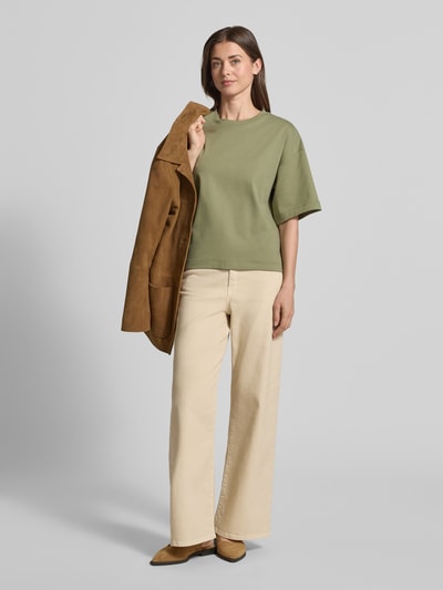 Vrouwenmodel draagt Oversized T-shirt uit puur katoen van s.Oliver RED LABEL, look: effen, oversized pasvorm, logo-applicatie, ronde hals, korte mouw, jersey, detail: puur katoen, kleur: lichtgroen, materiaal: effen structuur. Volledige lichaamsaanzicht van voren.