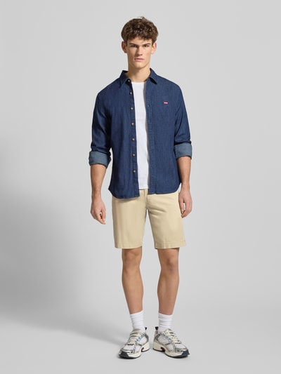 Männermodel trägt Straight Fit Chinos aus Baumwoll-Mix von Levi's®, Beige, Eingrifftaschen, Gesäßtaschen, Knopf- und Reißverschluss, Ganzkörperansicht von vorne.