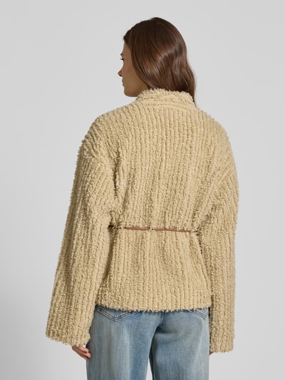 Frauenmodel trägt Jacke mit Bindegürtel Modell 'KIRA' von YAS aus beigefarbenem Teddyfell, Relaxed-Fit, Rückenlänge 64 cm, Schulterbreite 42 cm, Brustweite 58 cm, Ärmellänge 68 cm, Ganzkörperansicht Rückansicht.