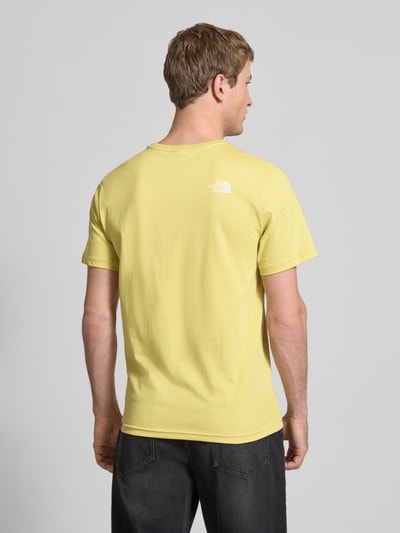 Mannelijk model draagt T-shirt met Labelprint van The North Face in geel, katoenmix, regular fit, ruglengte maat M 71 cm, rugaanzicht.
