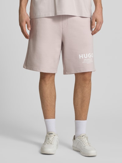 Männermodel trägt Loose Fit Sweatshorts aus reiner Baumwolle Modell 'Nomario' von Hugo Blue, Optik: Unifarben, Sweat, Nahaufnahme Unterkörper.