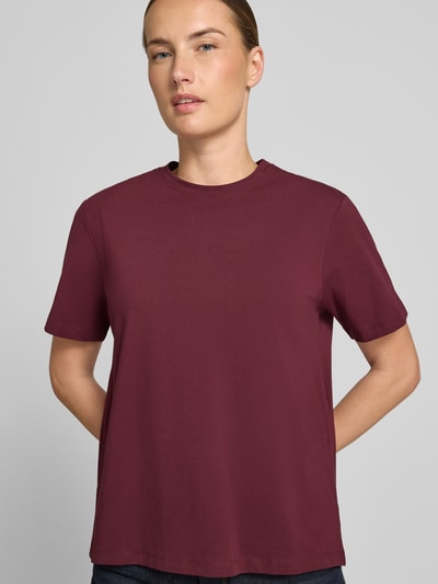 Frauenmodel trägt Damen T-Shirt mit Rundhalsausschnitt Modell 'NORA' von VILA aus Baumwoll-Elasthan-Mix in Bordeaux, Regular-Fit, Rückenlänge bei Größe S 60 cm, glatte Textur, Ganzkörperansicht von vorne.