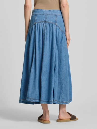 Frauenmodel trägt Jeansrock mit Schnürung Modell 'LONIA' von Bash in A-Linie, reine Baumwolle, mittlere Waschung, Ganzkörperansicht Rückansicht.