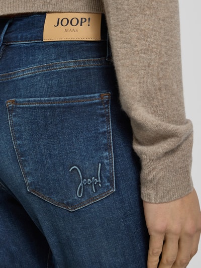 Kobiece model nosi Jeansy z 5 kieszeniami od JOOP! Jeans, mieszanka bawełny ze streczem, slim fit, detal logo, zapięcie na guzik i zamek, detailaufnahme tyłu.