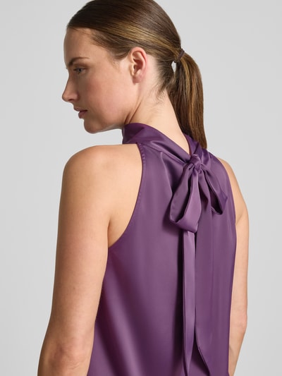 Frauenmodel trägt Blusentop mit Zierschleife Modell 'PELLA' von YAS in Lila, Satin-Optik, elastischer Material-Mix, Nahaufnahme Rückansicht.