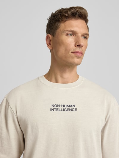 Männermodel trägt T-Shirt mit Rundhalsausschnitt Modell 'Gary' von Wood Wood aus reiner Baumwolle im Relaxed-Fit, Nahaufnahme Oberkörper.