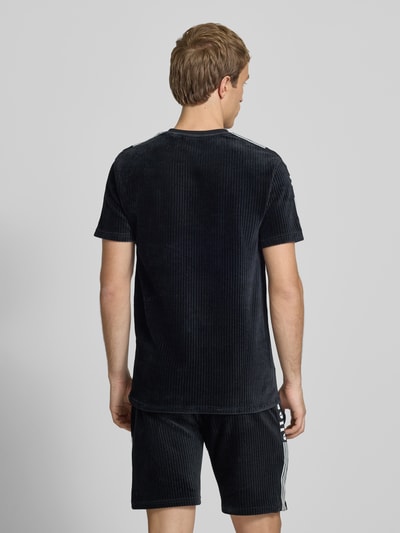 Männermodel trägt Herren T-Shirt mit Logo Modell 'MADORI' von Ellesse, Baumwoll-Mix mit Stretch-Anteil, Regular-Fit, Rückenlänge 66 cm, Ganzkörperansicht Rückansicht.