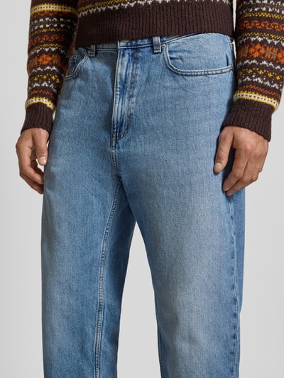 Männermodel trägt Baggy Jeans in klassischem Five-Pocket-Design von Review, blaue Waschung, Reine Baumwolle, Relaxed Fit, Nahaufnahme Oberkörper.