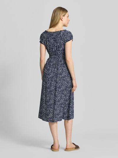 Modelka kobieca nosi 'Knielanges Kleid aus Viskose im Allover-Look' od Apricot w kolorze granatowym z białym wzorem, czysta wiskoza, krój dopasowany w talii, długość do kolan, okrągły dekolt, długość pleców w rozmiarze S 106 cm, szerokość w rozmiarze S 43 cm, długość rękawa w rozmiarze S 11 cm, widok całej sylwetki z tyłu.