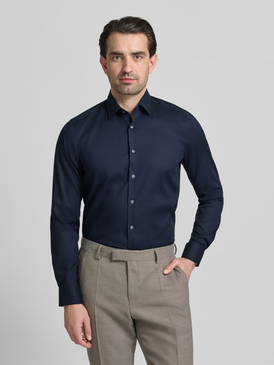 Männermodel trägt Regular Fit Businesshemd aus Baumwolle-Mix mit Kentkragen von OLYMP Level Five, dunkelblau, Ganzkörperansicht von vorne, strukturierte Oberfläche, durchgehende Knopfleiste, Sportmanschetten, langärmeliges Design, eleganter Look.