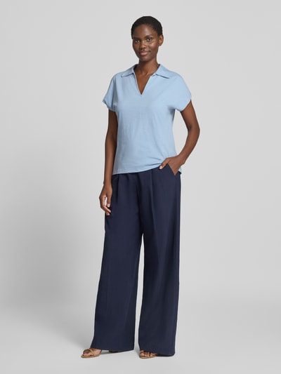 Frauenmodel trägt Regular Fit Poloshirt aus reiner Baumwolle von s.Oliver RED LABEL in Hellblau zu dunkelblauer Hose, Ganzkörperansicht von vorne.