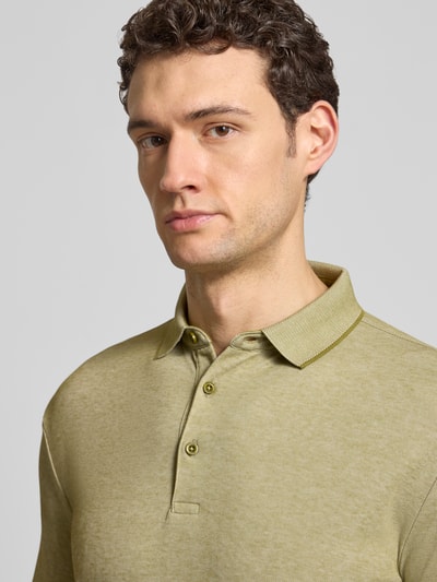 Männermodel trägt Slim Fit Poloshirt mit Label-Detail von HECHTER PARIS in olivgrün, Baumwollmischung, Nahaufnahme Oberkörper.