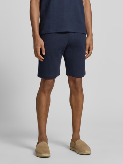 Männermodel trägt Regular Fit Shorts mit Tunnelzug von MCNEAL aus Baumwoll-Mix mit Stretch-Anteil, Eingrifftaschen, Gesäßtasche, Ganzkörperansicht von vorne.