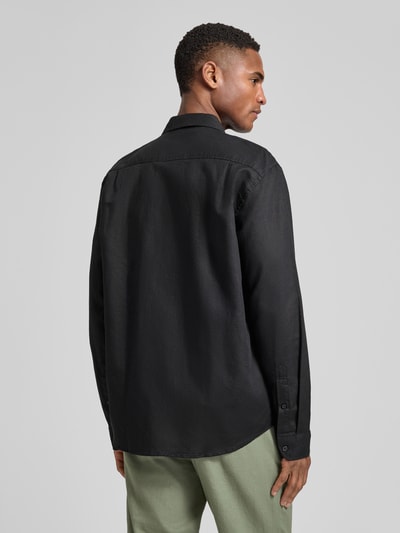 Männermodel trägt Regular Fit Freizeithemd aus Leinen-Baumwoll-Mix Modell 'CLAY LINENBLEND' von SELECTED HOMME in Schwarz, Melange-Optik, Flammgarn, 2-Knopf-Manschette, Rückansicht Ganzkörperansicht.